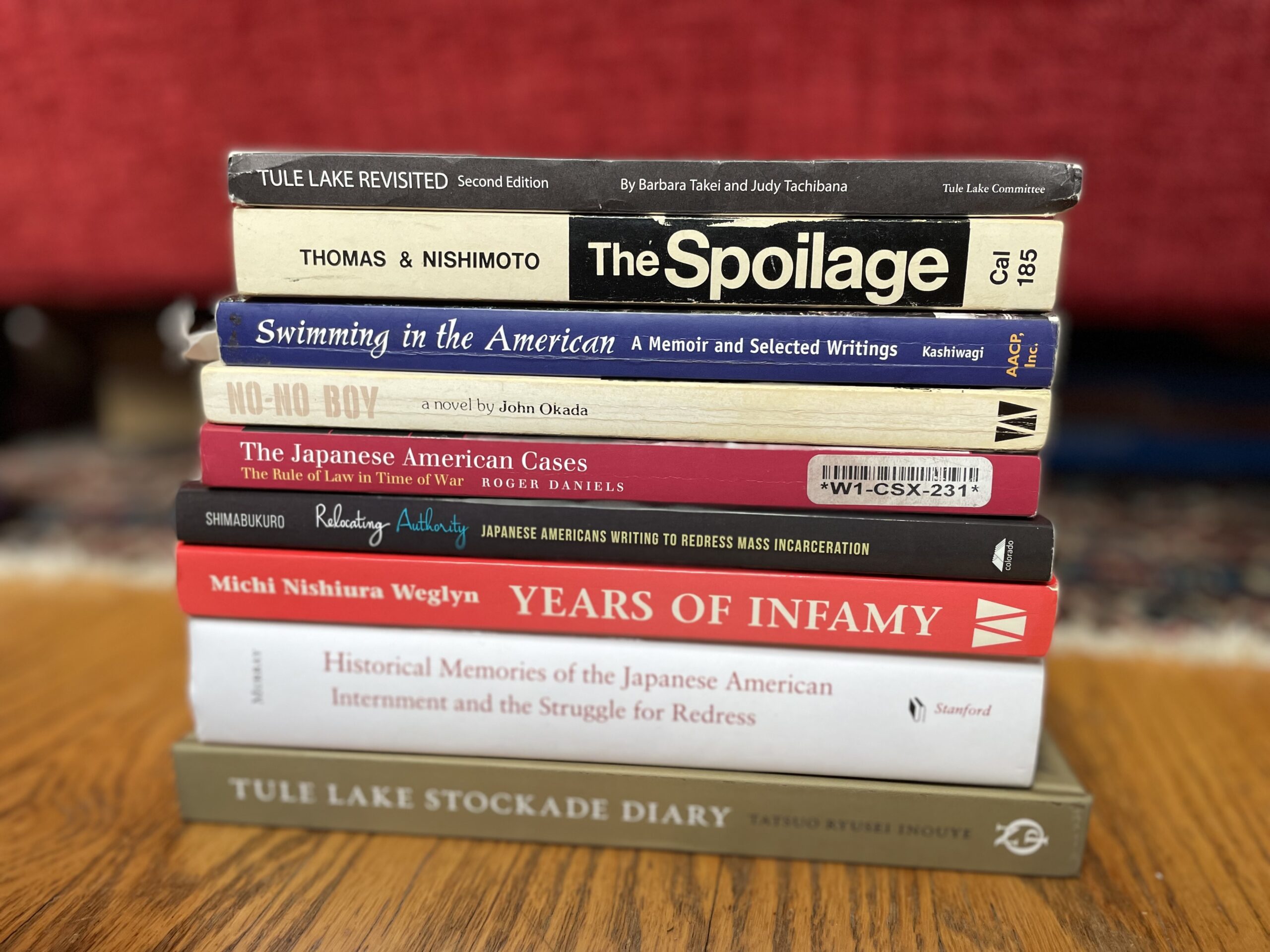 A horizontal stack of books related to the Japanese American wartime incarceration.